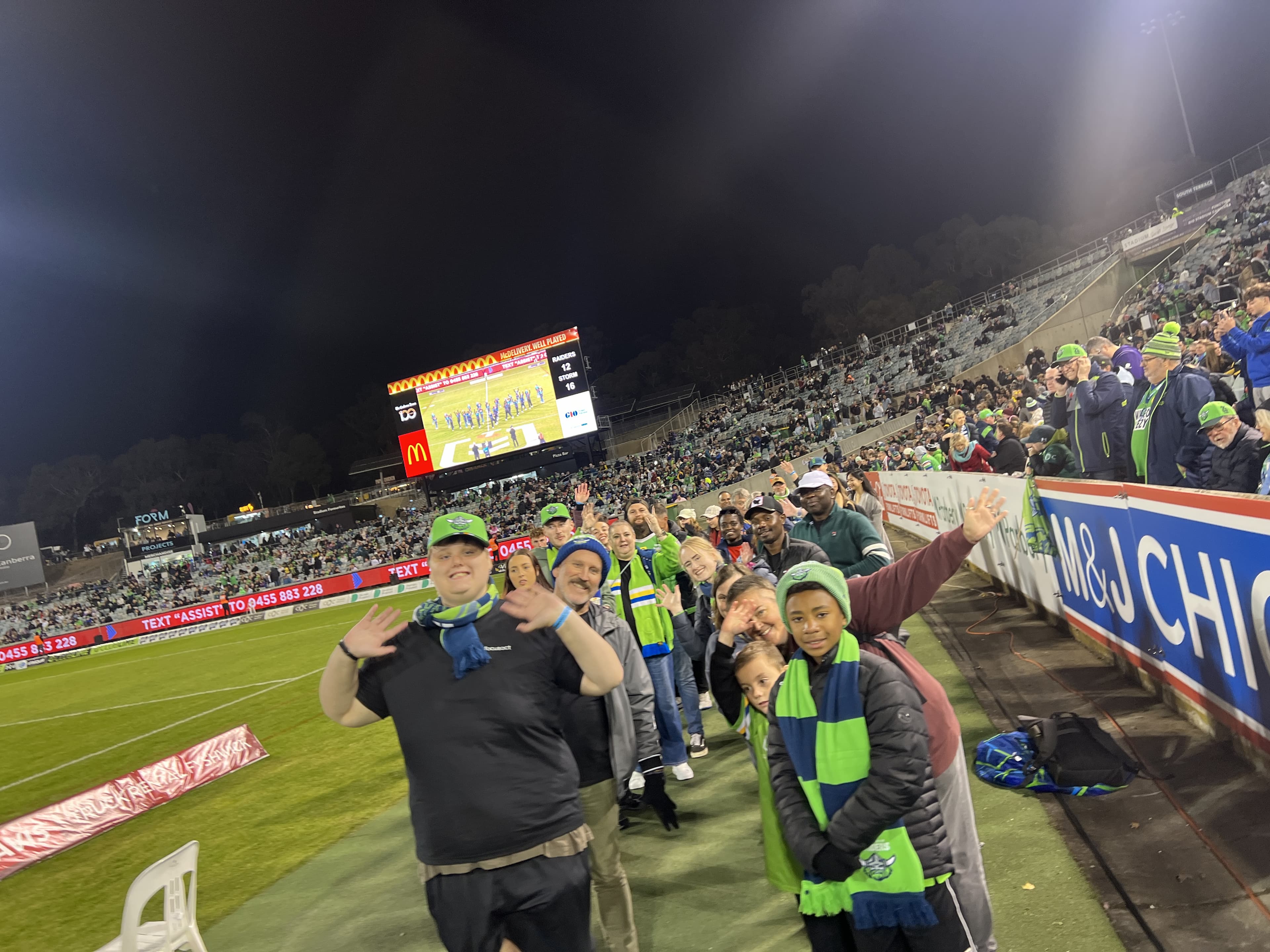 Focus ACT participants and staff cheering together at a Canberra Raiders game